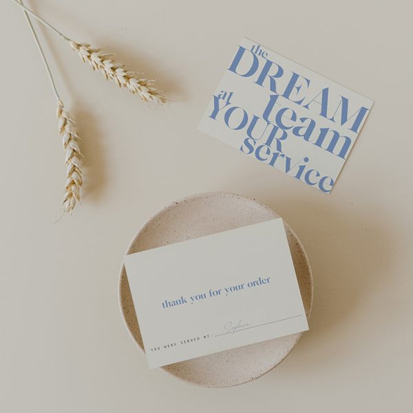 Snygg grafisk design av tackkort ljusblå text på krämfärgad bakgrund